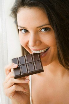 Hispanic woman eating chocolate bar