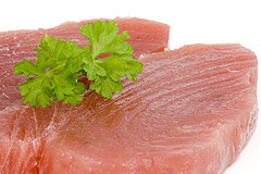 Uncooked tuna steaks with parsley sprig