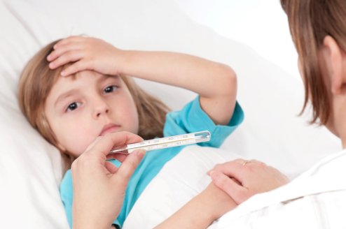 Sick little girl in bed. Mother with thermometer